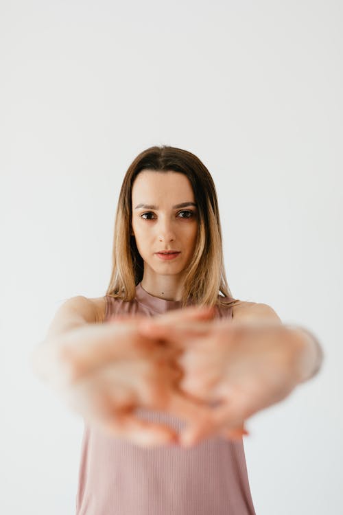 Free Focused young lady stretching wrists in light studio Stock Photo