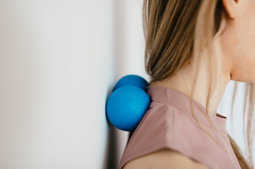 Close-Up Photo of a Woman Pressing Her Neck on a Stress Ball