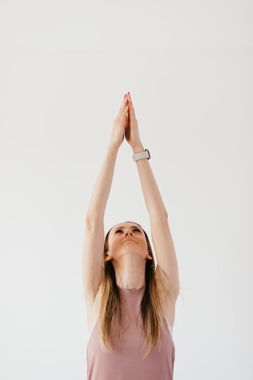 Young woman performing Mountain with Arms Up exercise at home
