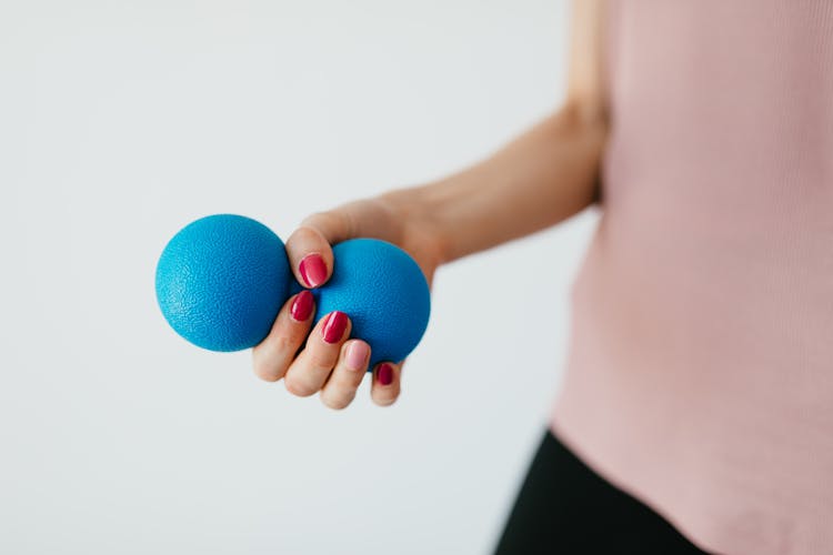 Faceless Young Woman With Stress Ball On White Background