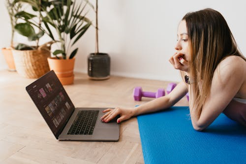 Young woman surfing laptop before exercising
