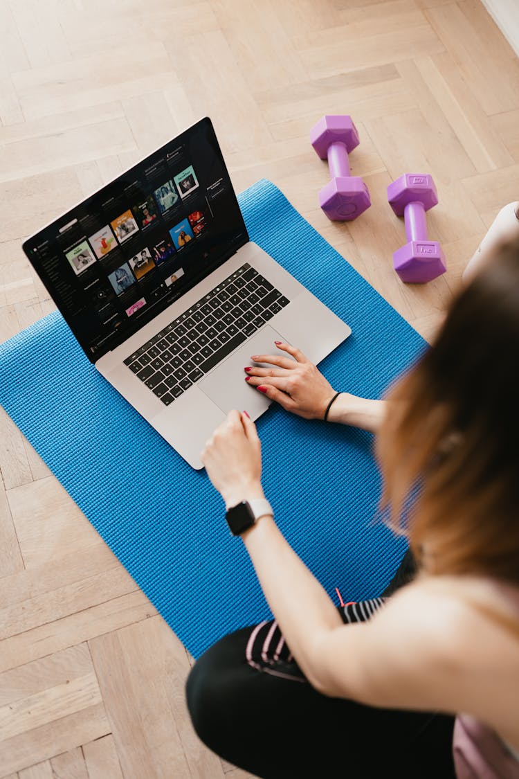 Faceless Woman Using Laptop On Rubber Mat