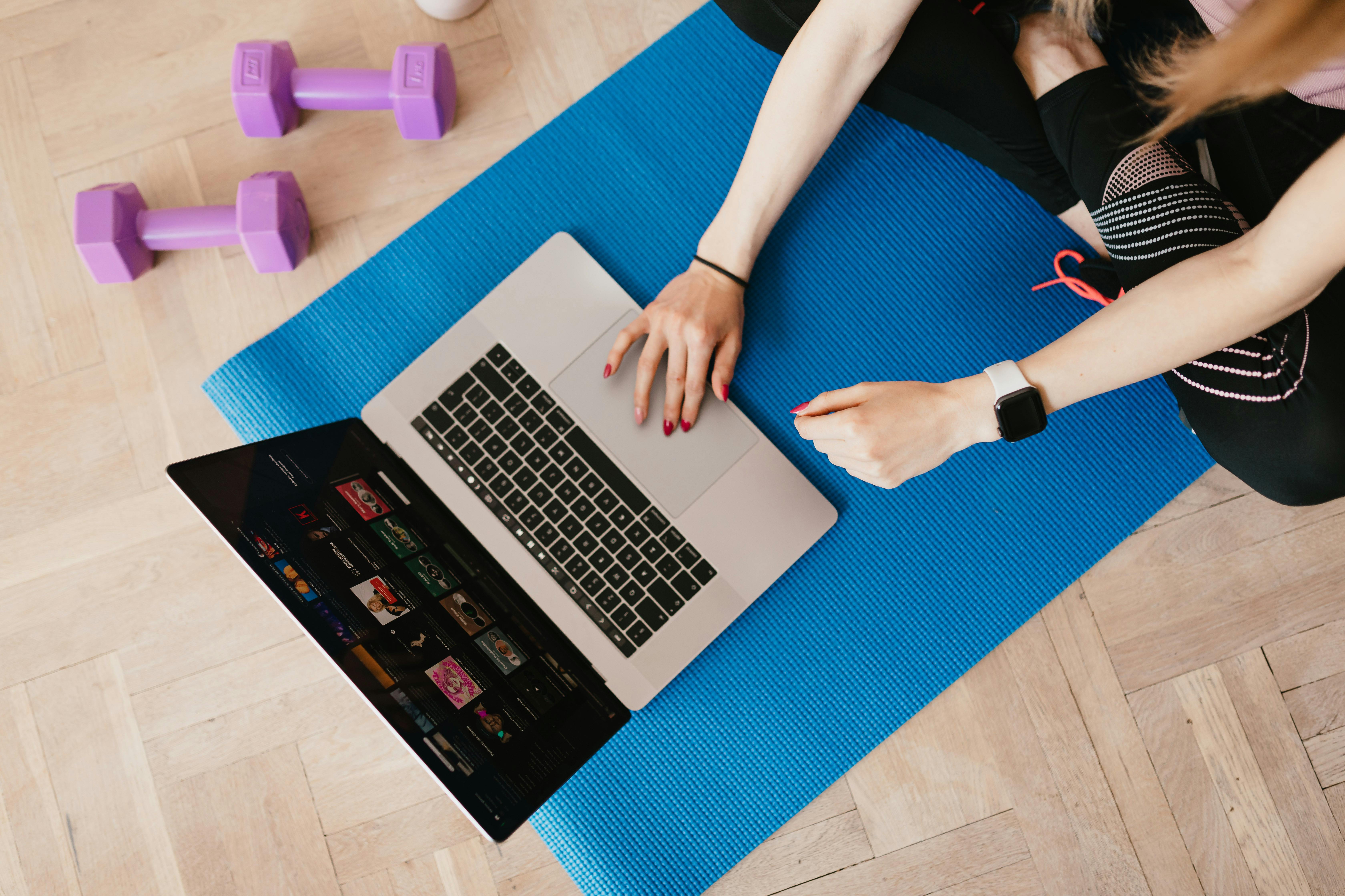 unrecognizable woman using laptop on mat