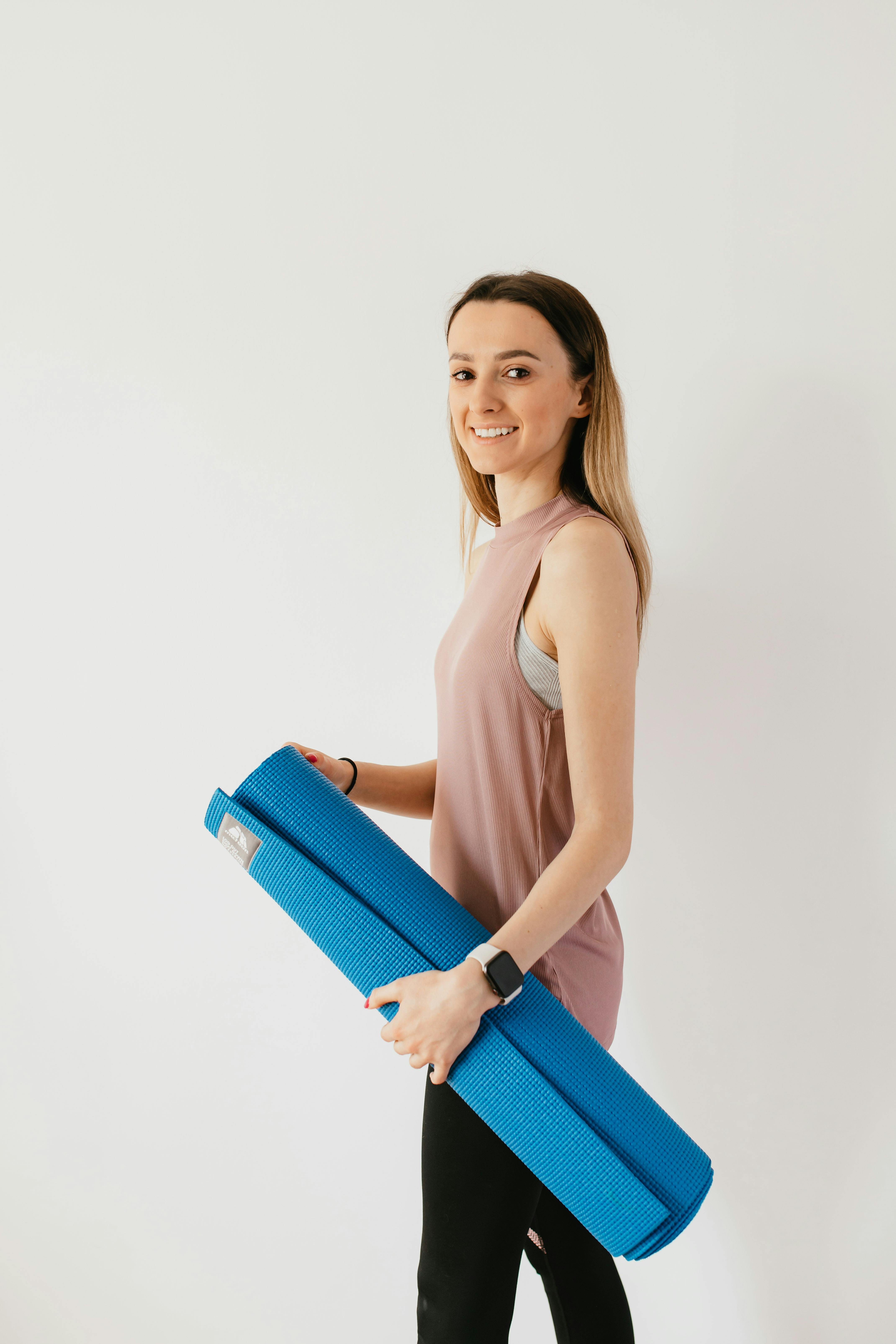 cheerful young woman with sport mat