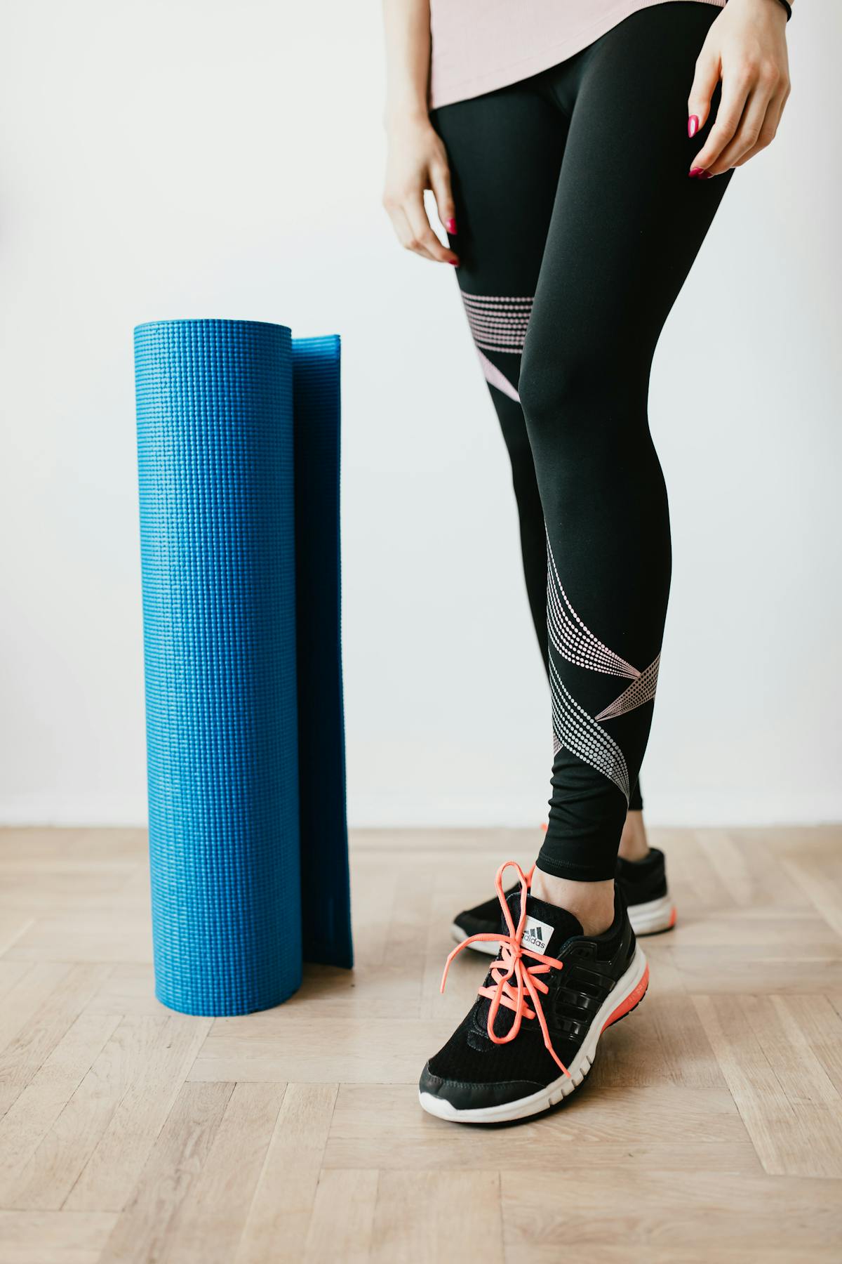 Woman following a guided workout routine from her phone on a yoga mat at home