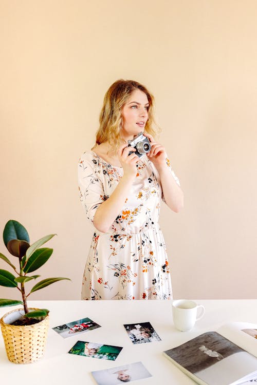 Woman in Floral Dress Holding a Camera