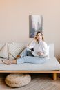 Woman in White Long Sleeve Shirt Sitting on White Couch