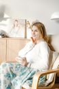 Woman in White Sweater Sitting on Bed