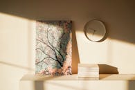 米色墙上，极简主义的装饰包括抽象绘画、时钟和柔和的阴影