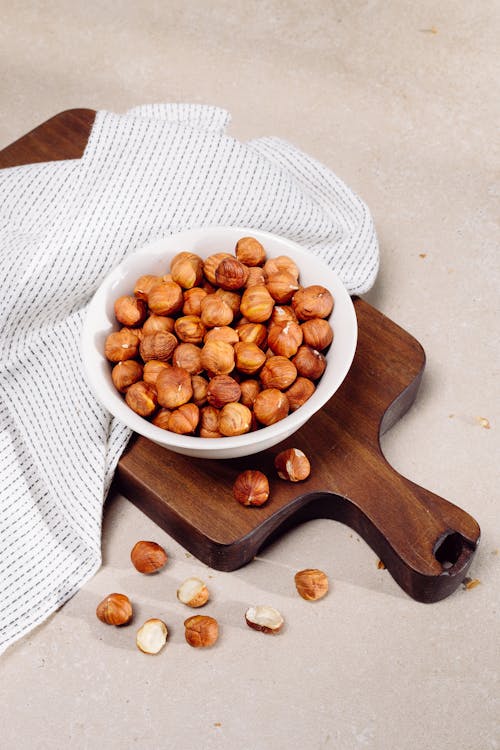 Free Hazelnuts in White Bowl on Cutting Board Stock Photo