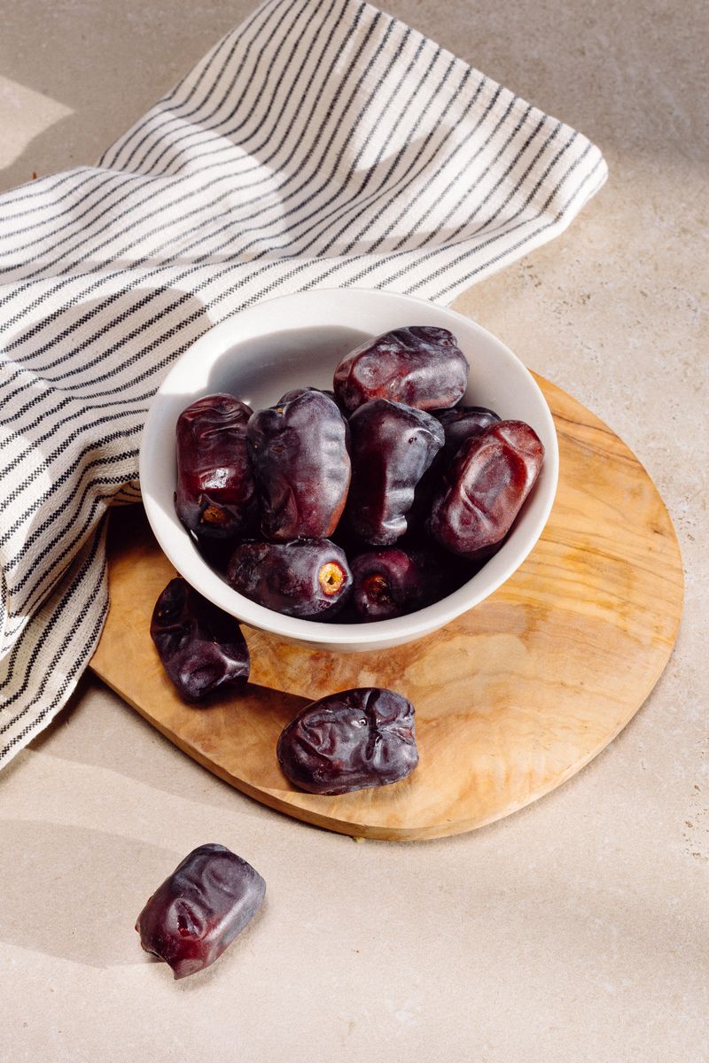 Raw dates and date seeds on a wooden board
