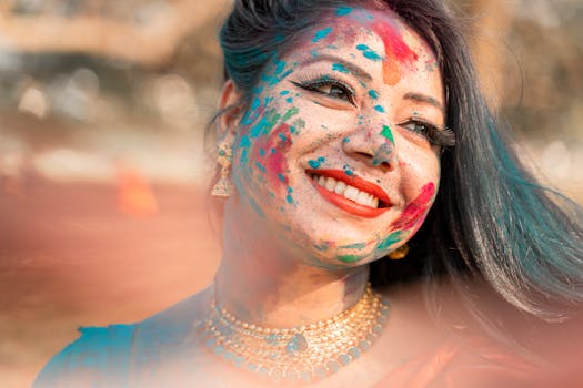 Smiling woman covered in colorful powders during Holi festival in Kolkata, India.
