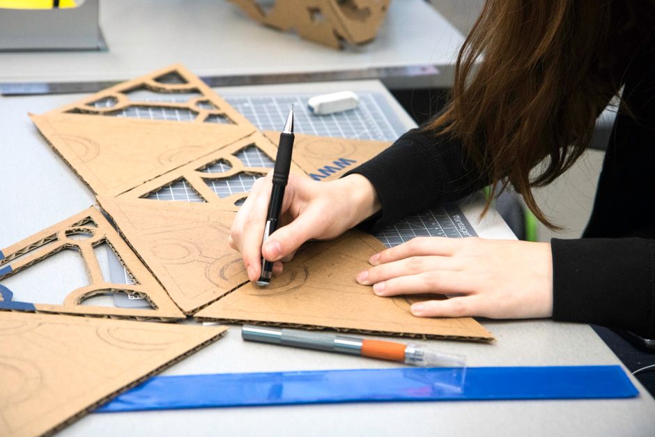 A student sketching architectural designs at a desk