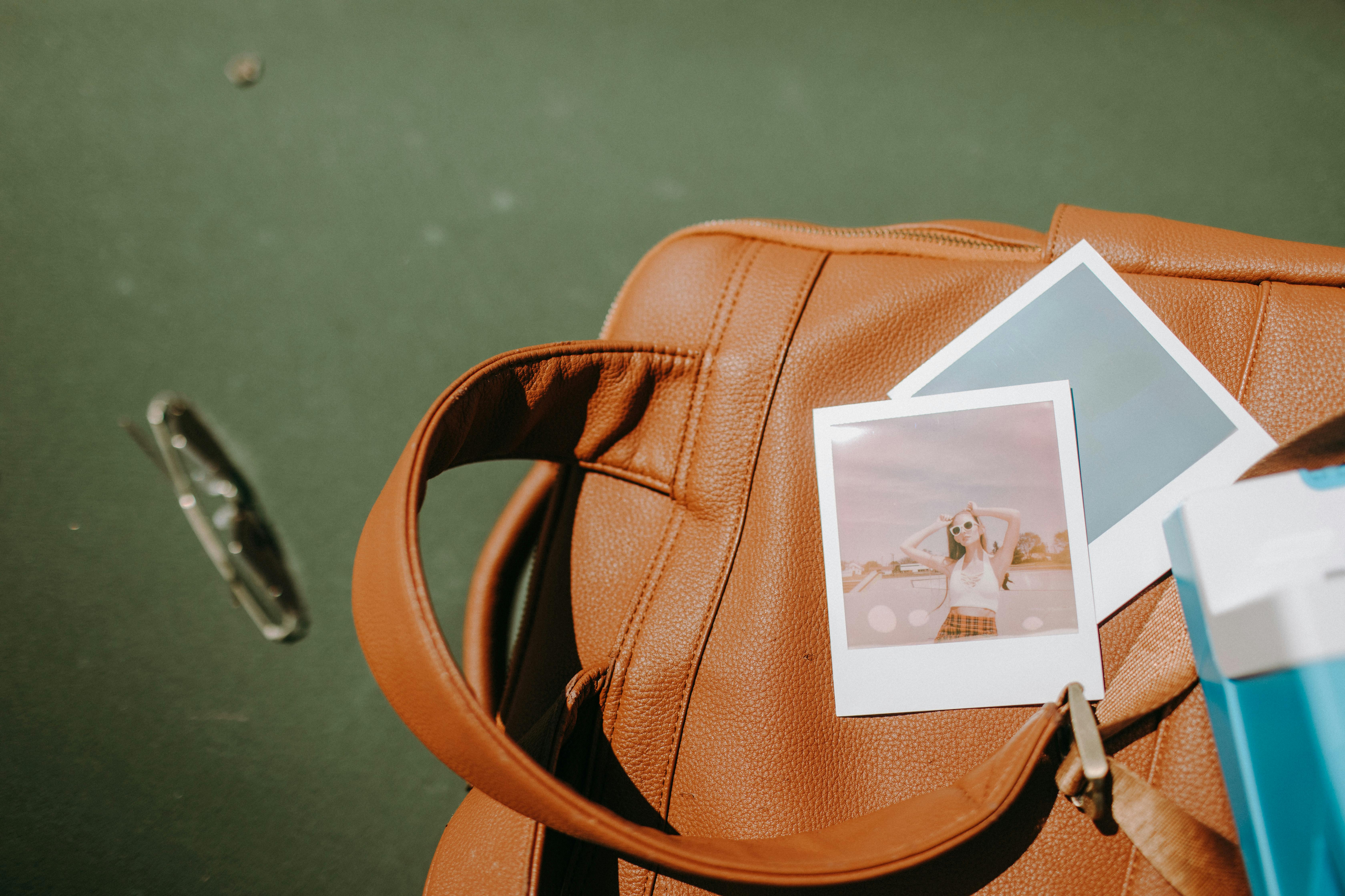 instant photo of a woman on brown leather handbag