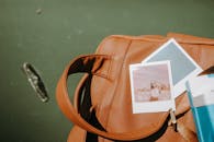 棕褐色皮包上放置的宝丽来照片户外特写