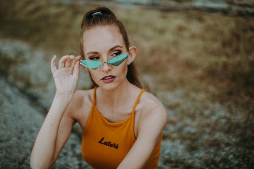 A Woman in Yellow Tank Top Wearing Sunglasses