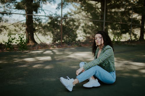 Woman in Denim Jeans Sitting on the Floor