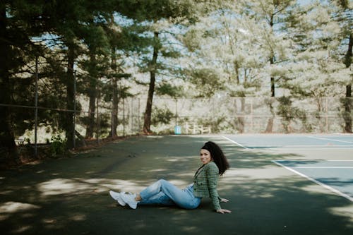 A Woman in Green Blazer and Denim Jeans Sitting