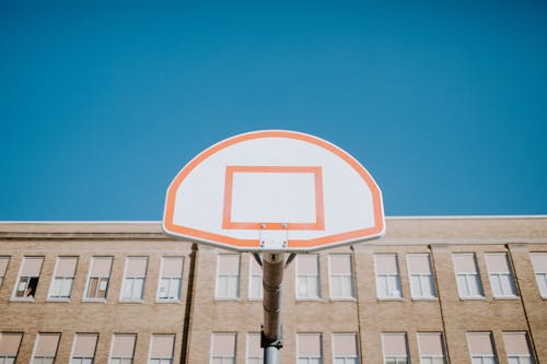 White and Red Basketball Backboard Under Blue Sky