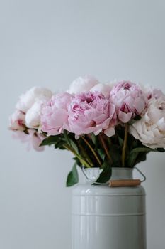 这款经典花瓶点缀着柔和的粉红色牡丹花束，其美学风格非常适合室内装饰