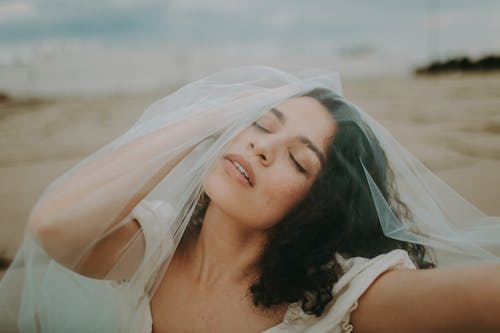 Woman in White Top and Veil With Eyes Closed