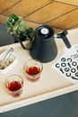 Tray with glasses of hot black tea and teapot