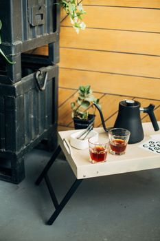 温暖而迷人的室内茶具，桌上配有黑色茶壶、茶具和木托盘，以及多汁植物