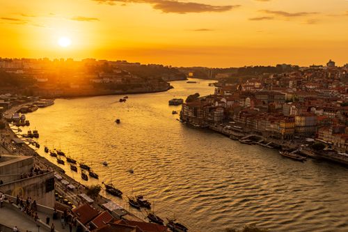 Free A breathtaking aerial view of Porto at sunset, showcasing the Douro River and cityscape. Stock Photo