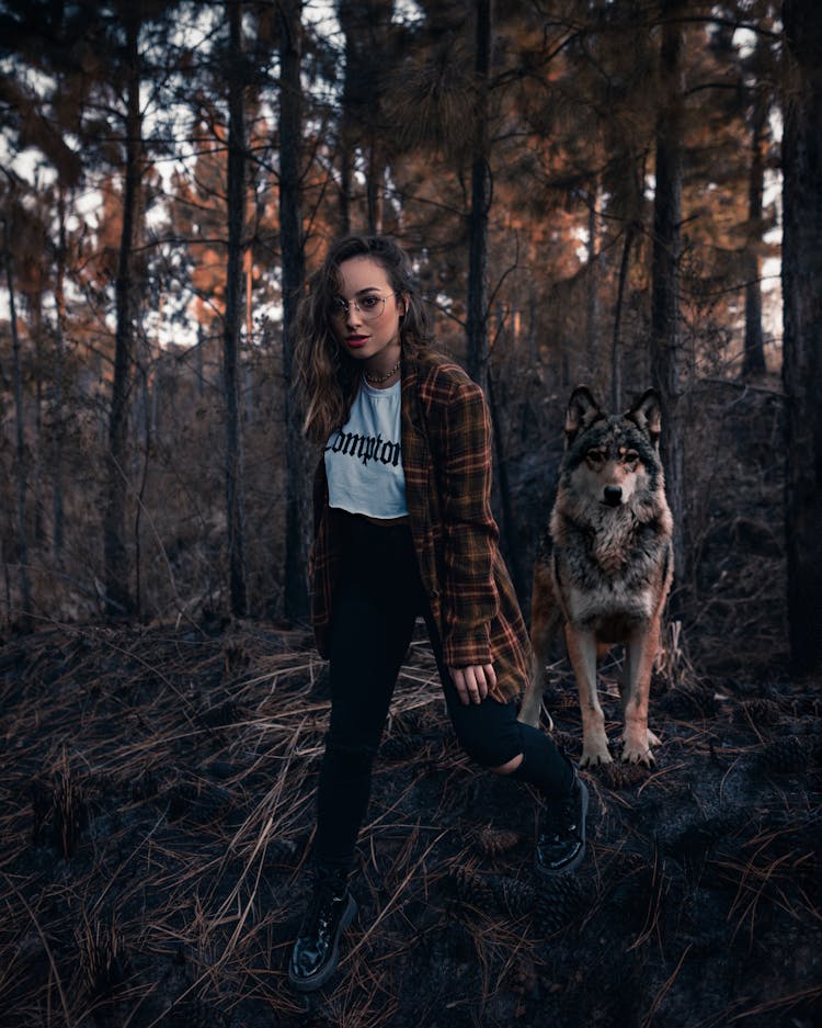 Woman In Checkered Long Sleeves Shirt Walking With A Dog In The Woods