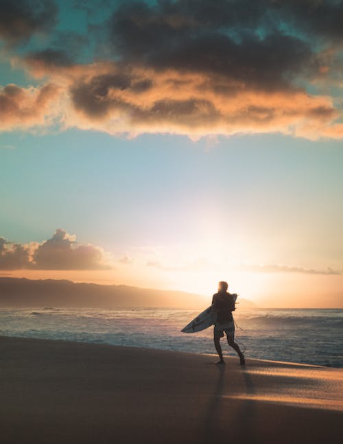 Man Carrying A Surfboard