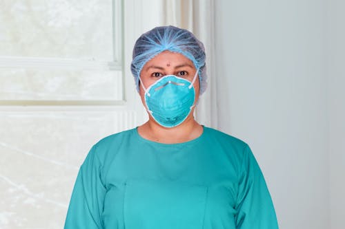 Free Woman in Blue Scrub Suit and Blue Surgical Mask Stock Photo