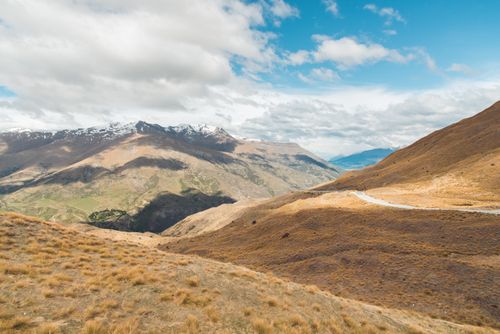 Free A beautiful mountain landscape with a winding road and clear skies, perfect for nature enthusiasts. Stock Photo