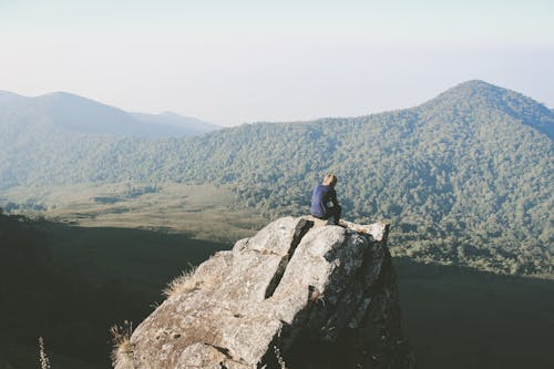 Free Person Sitting on Top of Mountain Stock Photo