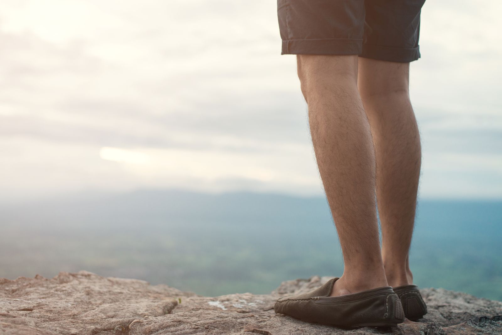 Hiker wearing knee-high socks on a bright mountain trail