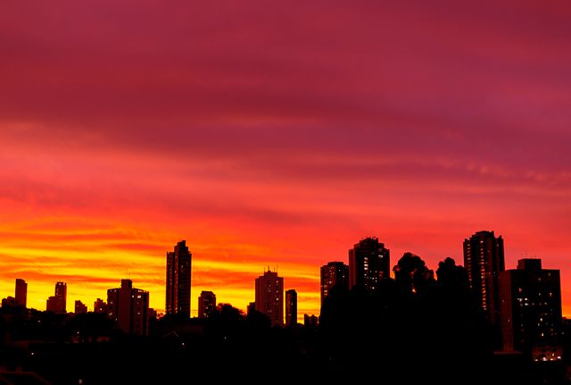 Stunning São Paulo skyline silhouetted against a vibrant orange and red sunset.
