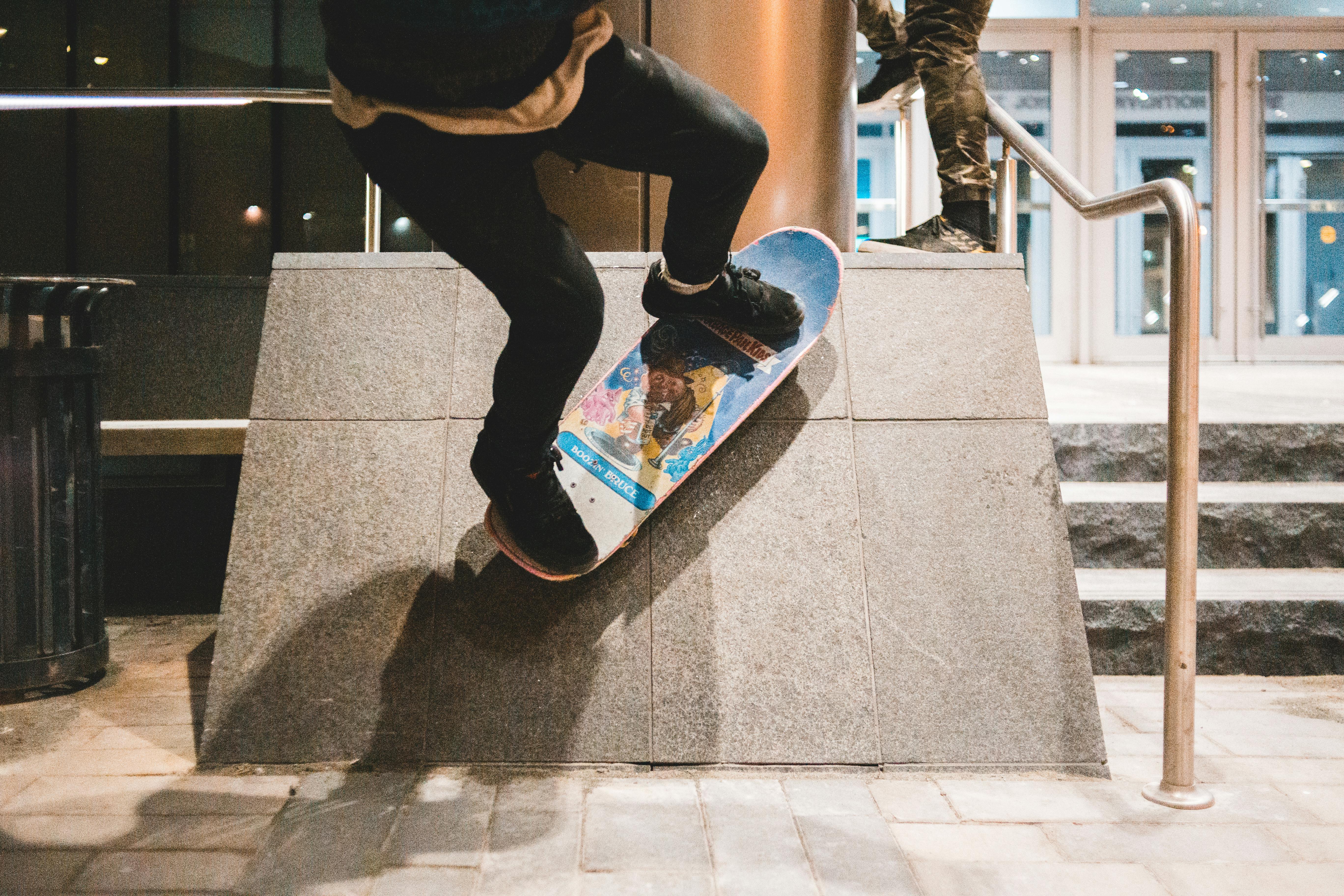 A skateboarder performs a trick on a ramp in an urban setting, showcasing skill and urban culture.