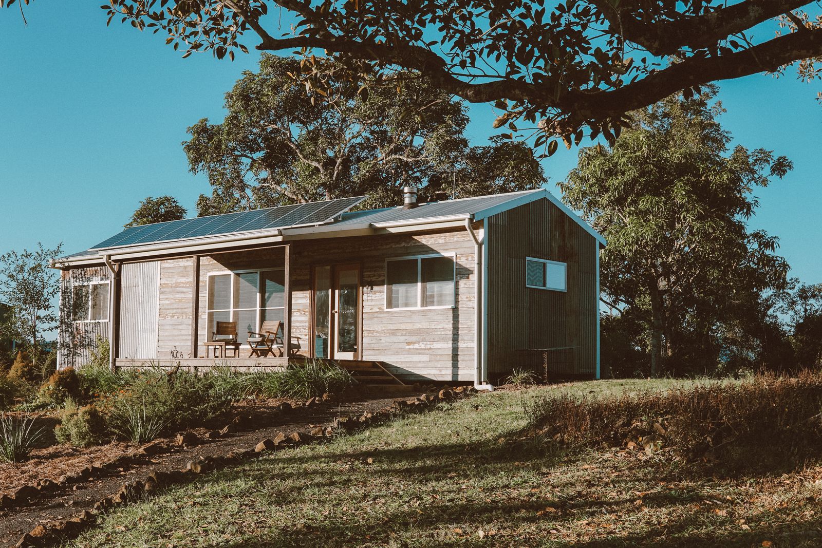 Australian home with rooftop solar panels surrounded by greenery