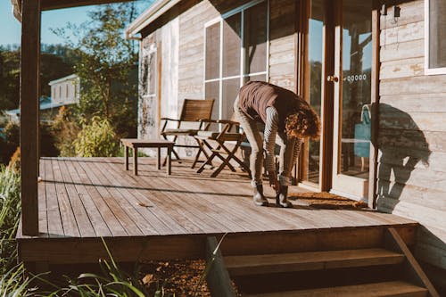 Woman Putting on Boots on the Patio