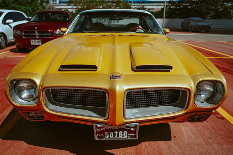 Yellow Pontiac Car In A Parking Lot