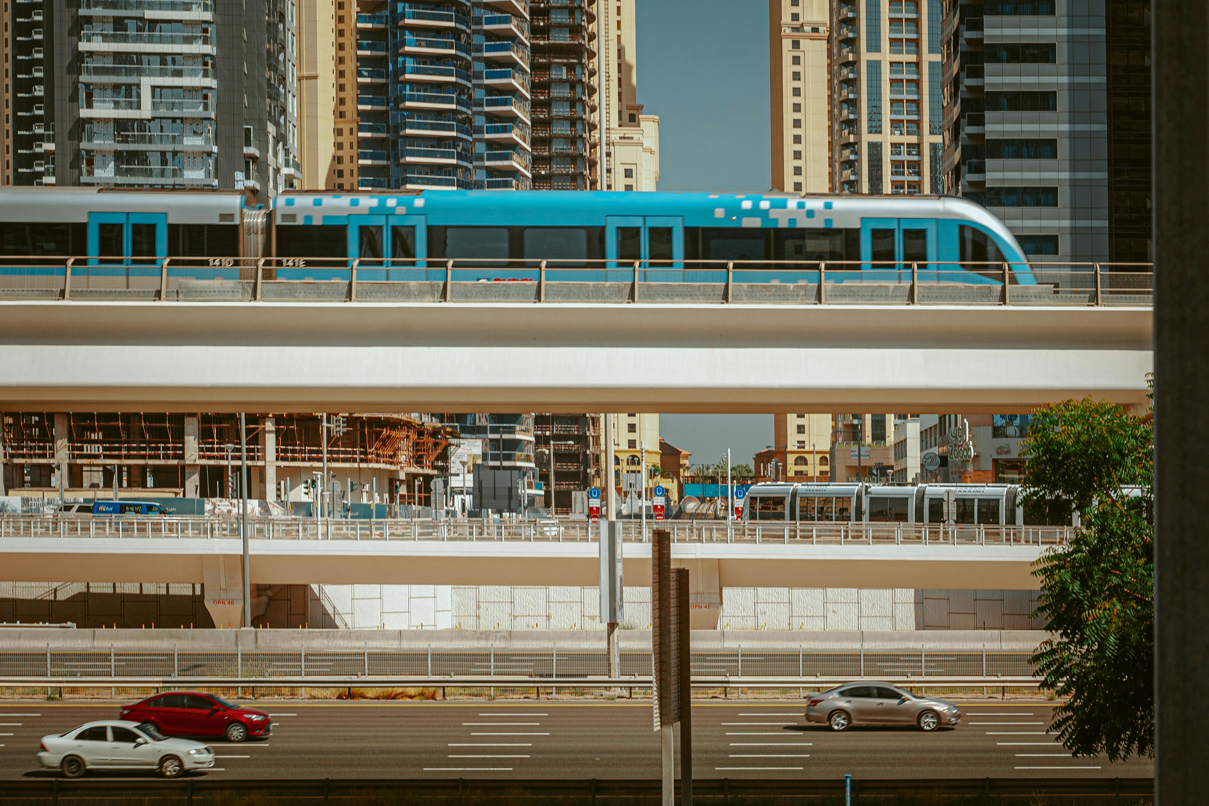 modern train driving on bridge above road in city