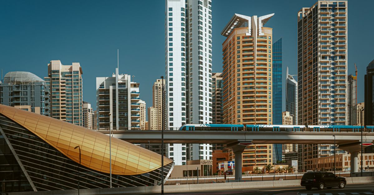 Stunning view of modern Dubai skyline featuring iconic highrise buildings and metro train.