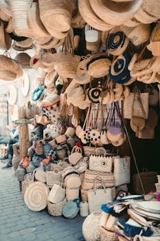 Vibrant display of handmade woven bags and hats in a Marrakesh street market.