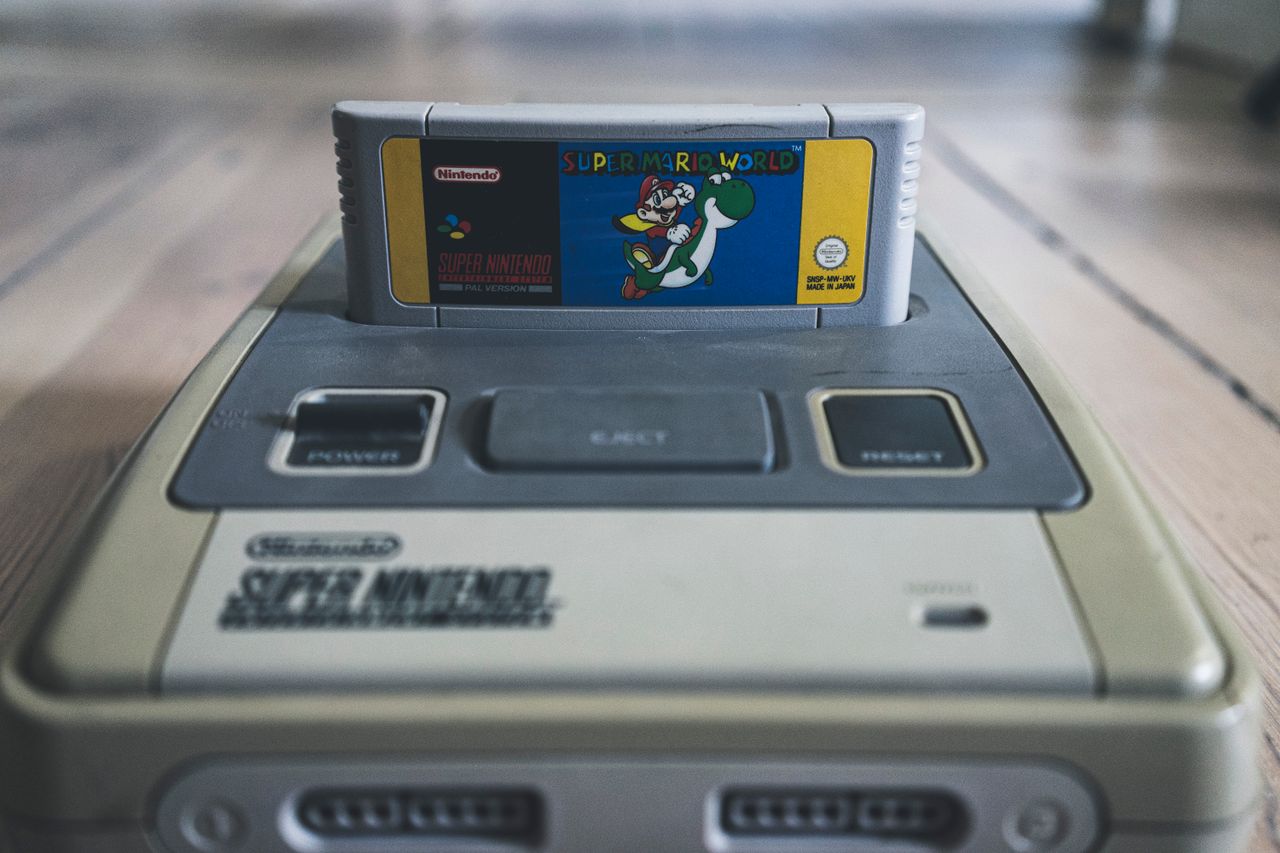 vintage video game console with cassette with bright sticker on surfac