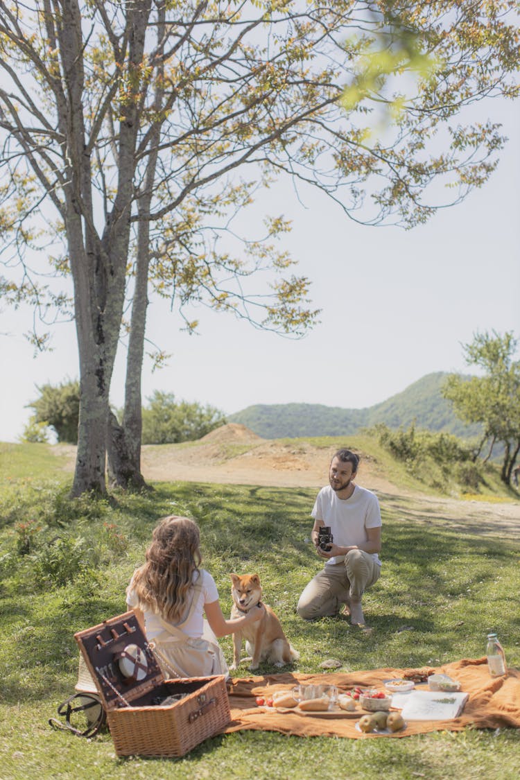 A Man Taking Photo Of A Woman And A Dog