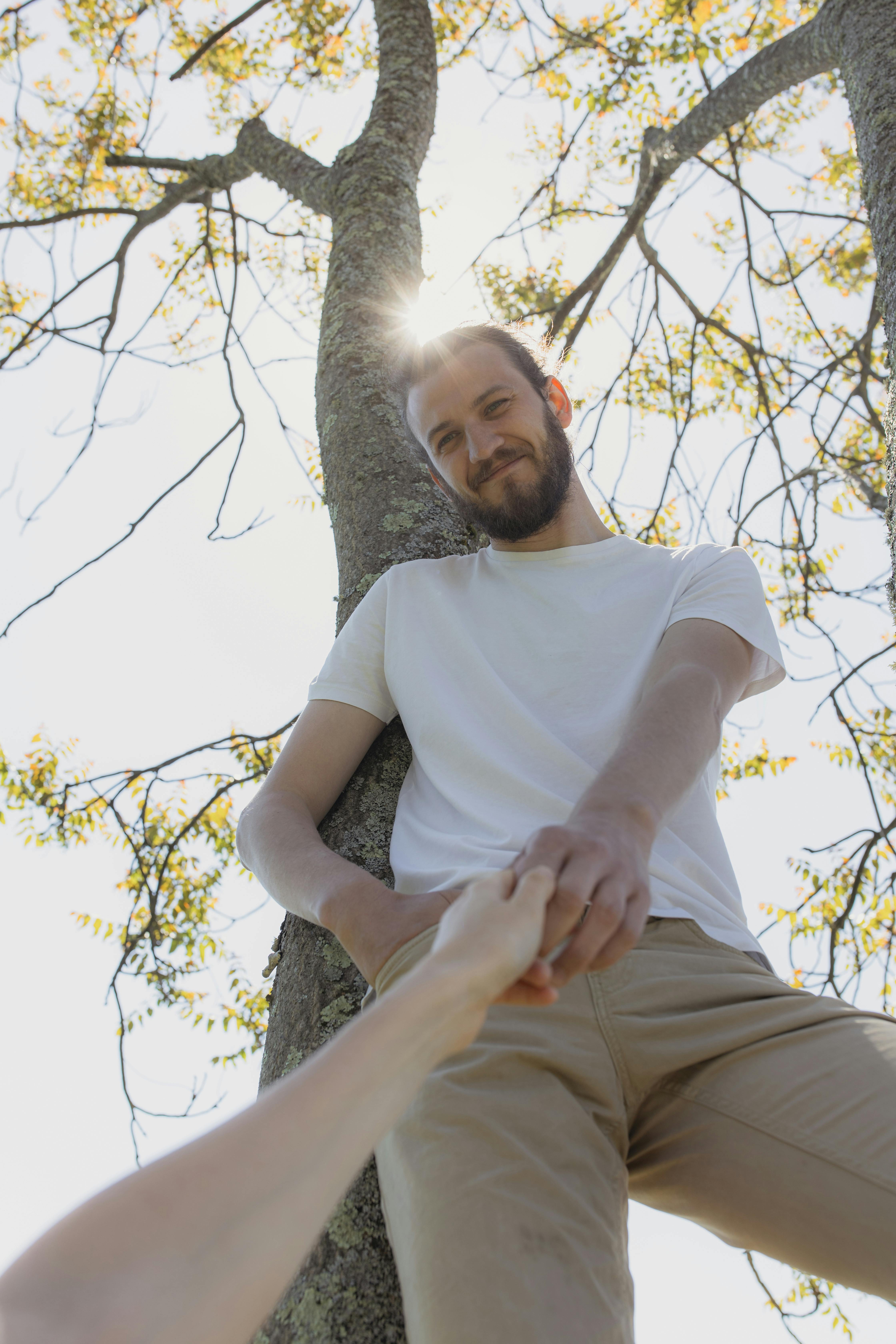 阳光明媚的喜悦时刻，捕捉到树枝下一个男人手牵着手