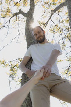 阳光明媚的喜悦时刻，捕捉到树枝下一个男人手牵着手