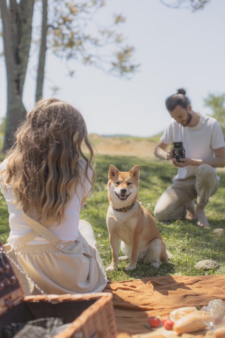 A Bearded Man Taking Photo Of A Woman And A Dog