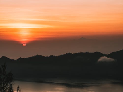 Silhouette of Mountains Near Body of Water during Sunset