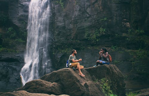 免費 男人和女人在瀑布附近 圖庫相片