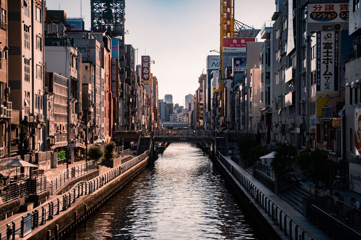 Dotonbori Canal in Osaka at sunset with urban architecture and vibrant city life